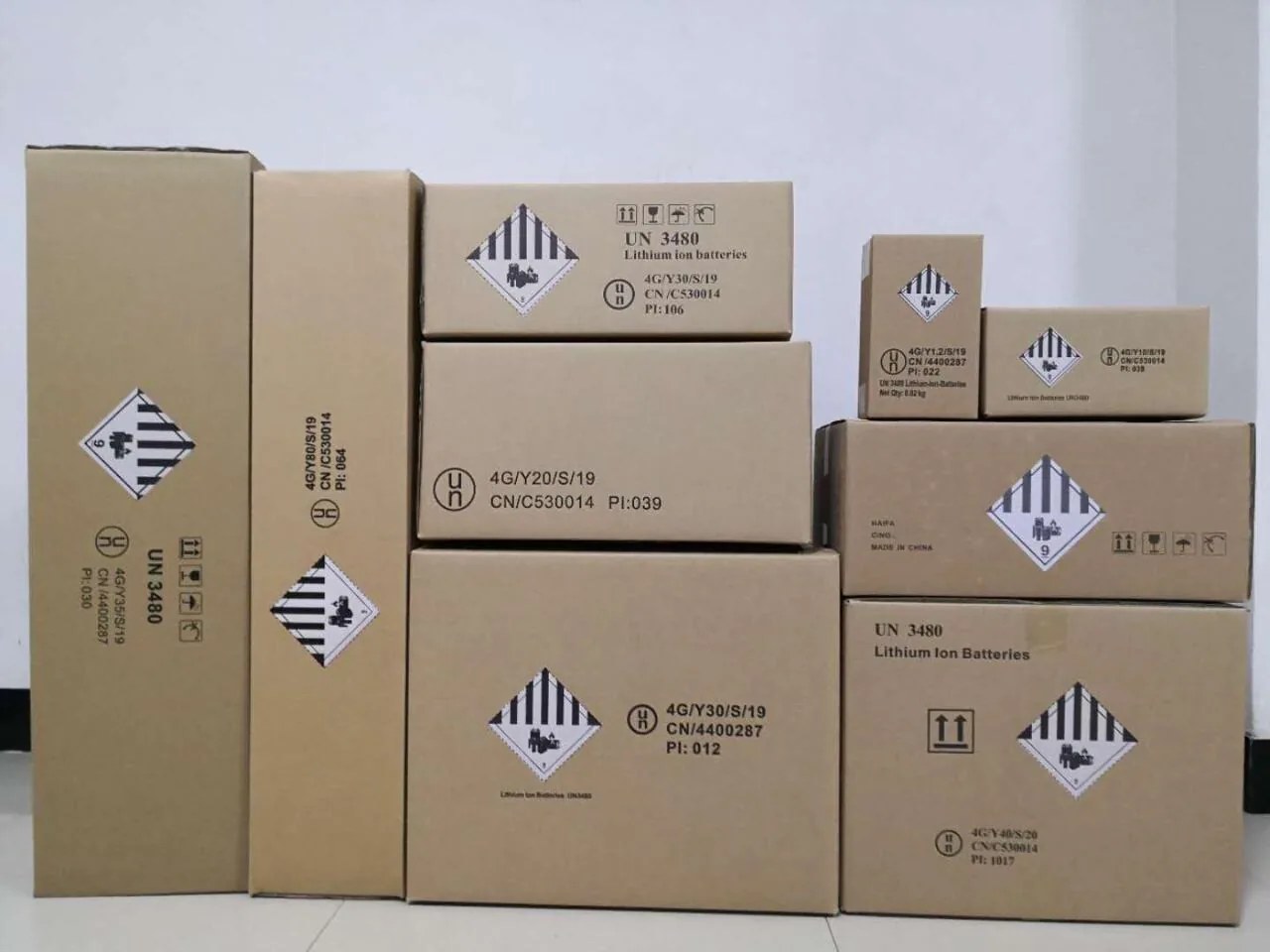 UN3480 lithium-ion battery cartons with Class 9 hazard labels stacked for air export in the Cargo163 warehouse